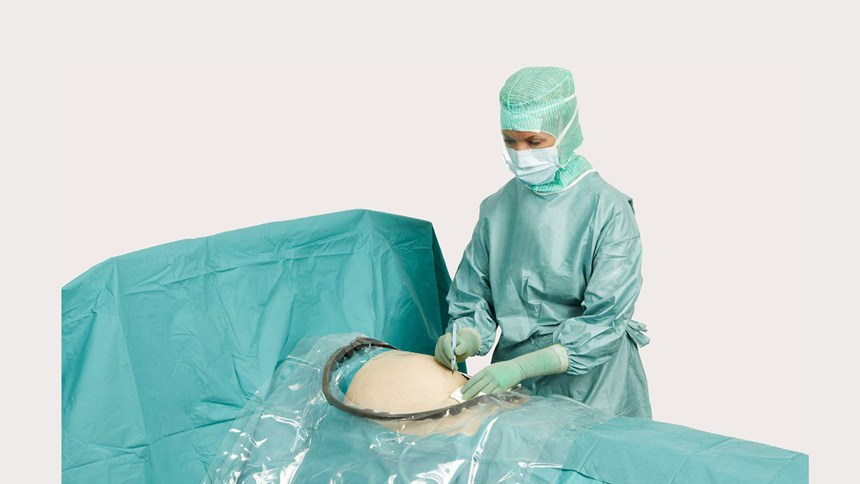 en kvinnlig kirurg som använder BARRIER® obstetriklakan